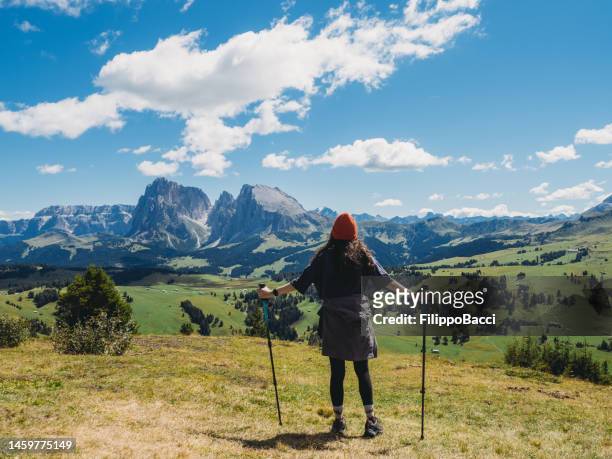 uma mulher está admirando a vista panorâmica de seiser alm em um dia ensolarado - alta badia - fotografias e filmes do acervo
