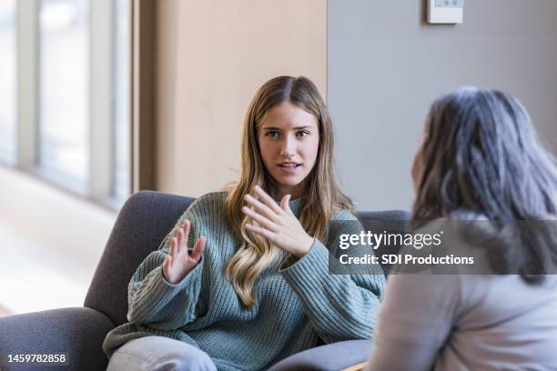 une jeune étudiante universitaire adulte discute avec son camarade - psychothérapeute photos et images de collection