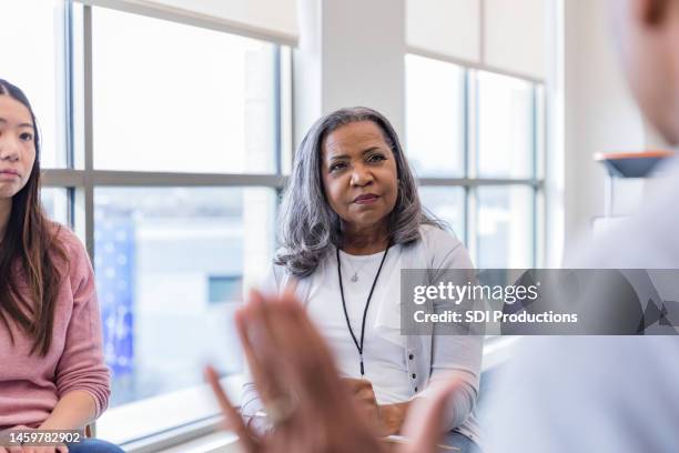 gruppentherapeut hört auf unkenntliche persönlichkeiten - african american mentor stock-fotos und bilder