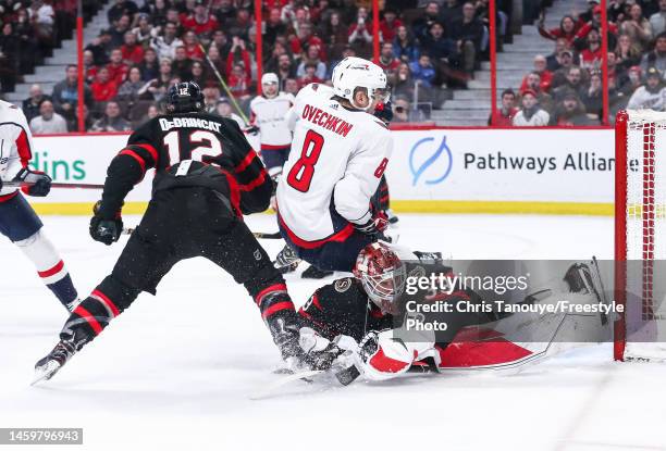 Alex Ovechkin of the Washington Capitals crashes into Cam Talbot as he battles with Alex DeBrincat during the third period of the game at Canadian...