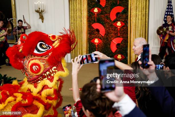 President Joe Biden looks on as members of the Choy Wun Lion Dance Troupe perform at a reception celebrating Lunar New Year in the East Room of the...