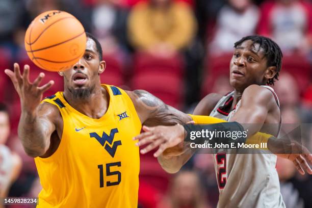 Forward Jimmy Bell Jr. #15 of the West Virginia Mountaineers battles for a loose ball against guard Elijah Fisher of the Texas Tech Red Raiders...