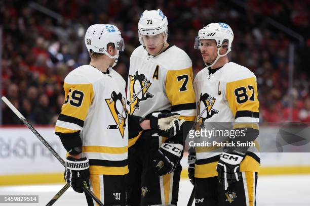 Sidney Crosby of the Pittsburgh Penguins talks with teammates Evgeni Malkin and Jake Guentzel against the Washington Capitals during the first period...