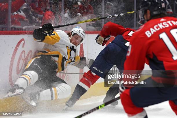 Brock McGinn of the Pittsburgh Penguins is checked by Marcus Johansson of the Washington Capitals during the second period at Capital One Arena on...