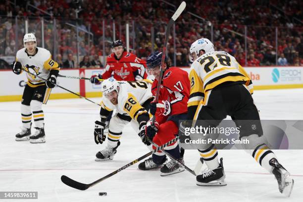 Dylan Strome of the Washington Capitals skates between Jeff Petry and Marcus Pettersson of the Pittsburgh Penguins during the second period at...