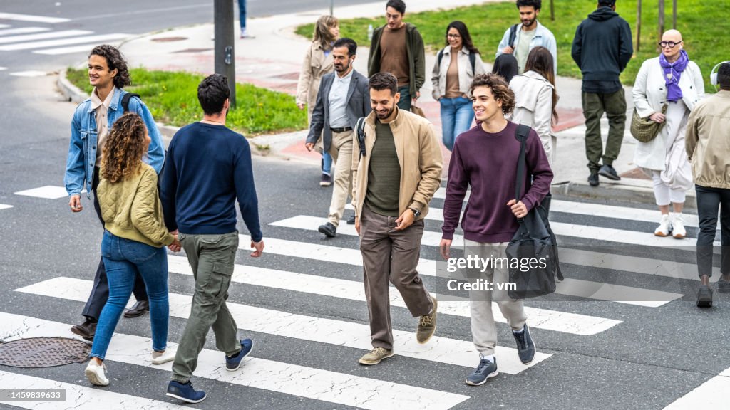 People walking across crosswalk in city downtown top view