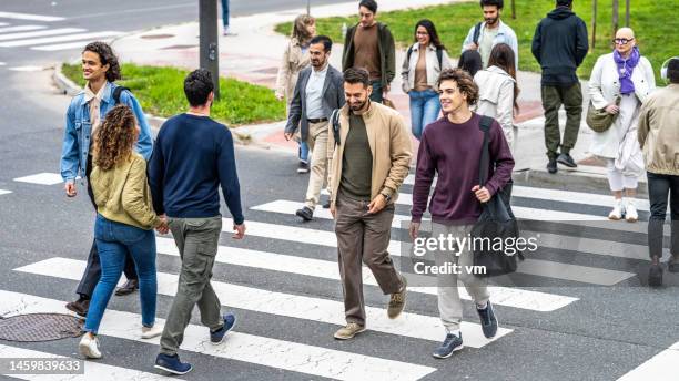 people walking across crosswalk in city downtown top view - zebrapad stockfoto's en -beelden