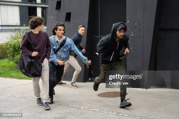 african american thief running at sidewalk with stolen items - thief stock pictures, royalty-free photos & images