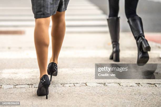 gambe della donna d'affari che attraversano la passerella indossando gonna e scarpe a spillo - tacchi alti foto e immagini stock