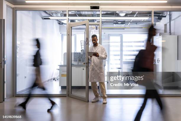 the laboratory assistant exits the laboratory. - assistant professor stock pictures, royalty-free photos & images