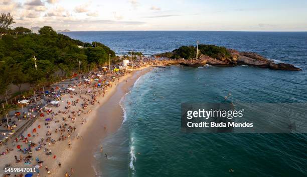 In an aerial view, Tourists and locals enjoy the sunset during the summer at Arpoador beach on January 26, 2023 in Rio de Janeiro, Brazil.
