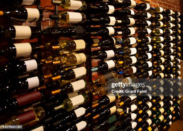 a wall rack of wine bottles. - weinkeller stock-fotos und bilder