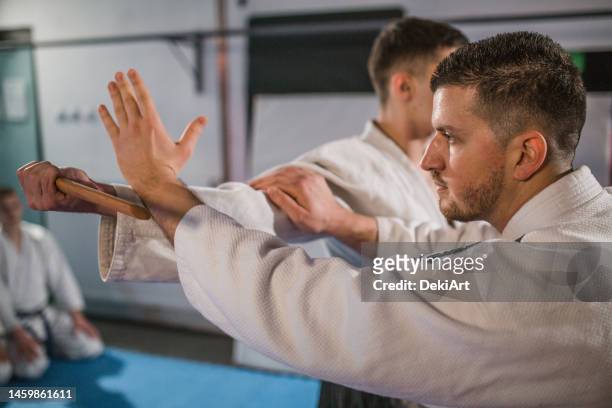 two fighters are fighting in the gym, aikido training is in progress - zelfverdediging stockfoto's en -beelden