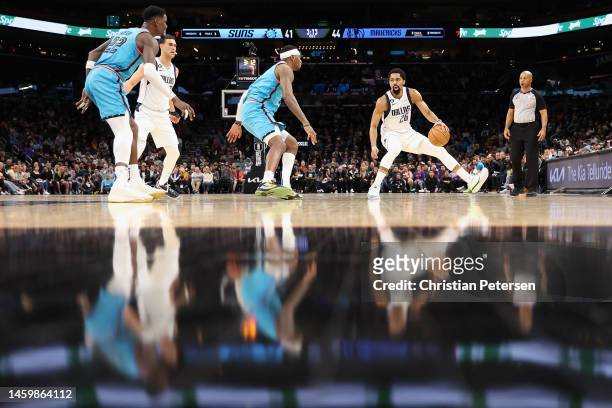 Spencer Dinwiddie of the Dallas Mavericks handles the ball against Torrey Craig of the Phoenix Suns during the first half of the NBA game at...
