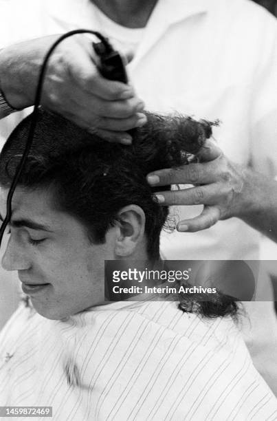 Soldier recently drafted into the United States Army closes his eyes as a barber shaves his head, Fort Jackson in Columbia, South Carolina, May 15,...