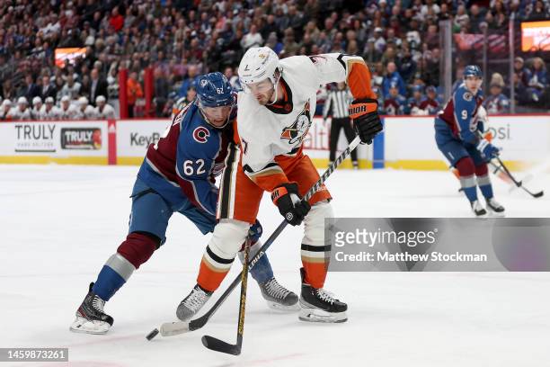 Artturi Lehkonen of the Colorado Avalanche fights for the puck against Jayson Megna of the Anaheim Ducks in the first period at Ball Arena on January...