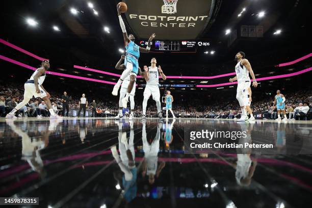 Deandre Ayton of the Phoenix Suns lays up a shot ahead of Dwight Powell of the Dallas Mavericks during the first half of the NBA game at Footprint...