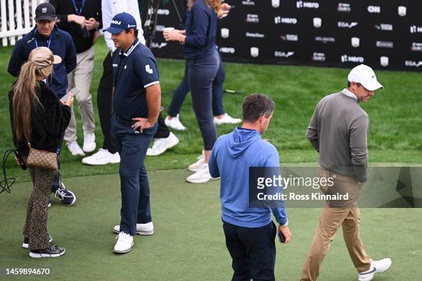 Rory McIlroy of Northern Ireland walks past Patrick Reed of The United States on the practice putting green on Day Two the Hero Dubai Desert Classic...