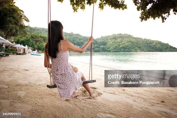 rear view a women swinging during summer vacation on a beach. - koh tao thailand stock pictures, royalty-free photos & images