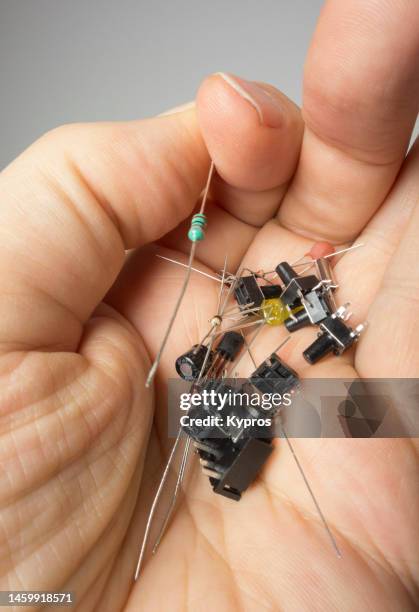 person with electronic component in hand - resistor stock pictures, royalty-free photos & images
