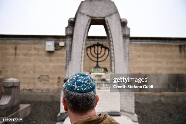 Man prays in front of a Jewish tomb during the commemoration of the Jewish victims of the Nazi deportation inside the Jewish Cemetery of Turin on...