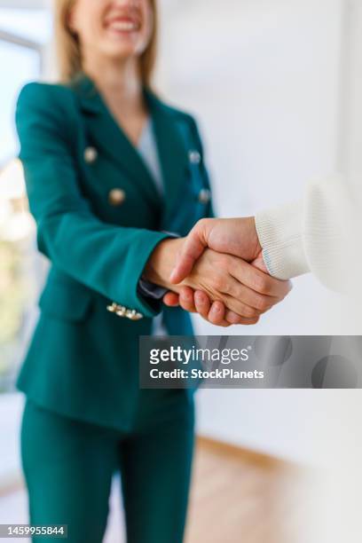 nahaufnahme von immobilienmakler und jungem mann beim händeschütteln - handshake close up stock-fotos und bilder