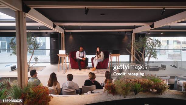 businessman giving speech in front of young entrepreneurs - conference event stage stock pictures, royalty-free photos & images