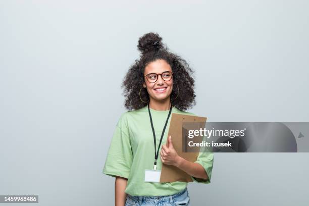 porträt eines lächelnden jungen freiwilligen - klemmbrett stock-fotos und bilder