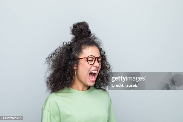 side view of young woman shouting - gritar imagens e fotografias de stock