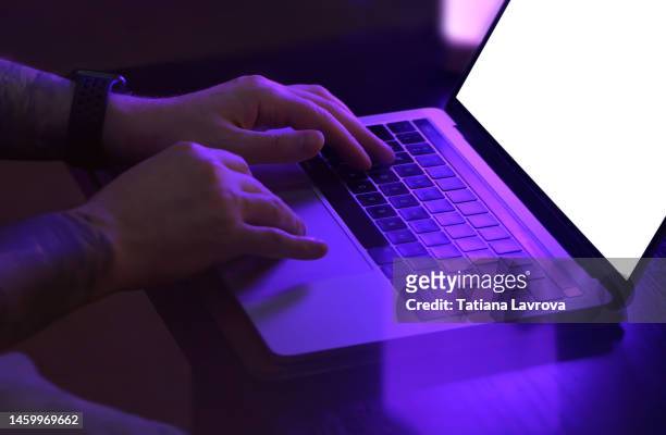 male hands typing on laptop with white screen in neon light. keyboard close up. technology, business, network security, online, internet, remote work concept - online messaging photos et images de collection