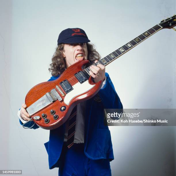 Angus Young of AC/DC, photo shoot dressed in school uniform holding a guitar, Tokyo, Japan, February 1982.