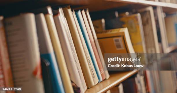 biblioteca, ricerca e fila di libri su scaffale per la lettura, la conoscenza e l'apprendimento educativo. libreria universitaria, informazioni e zoom degli scaffali con libro di testo, rivista accademica o letteratura - letteratura foto e immagini stock