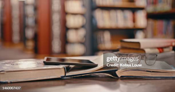 tablet, library background and books on table studying, learning or education with glasses. reading knowledge, philosophy research and university with vintage, history or print textbook on a desk - philosophy book stock pictures, royalty-free photos & images