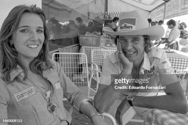 Portrait of Italian Formula One driver Arturo Merzario with an unidentified woman as they sit together during Italian Grand Prix, Monza, Italy,...