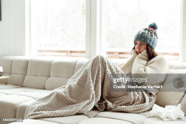 female shiver at freezing flat in warm clothes - warm clothing stock pictures, royalty-free photos & images