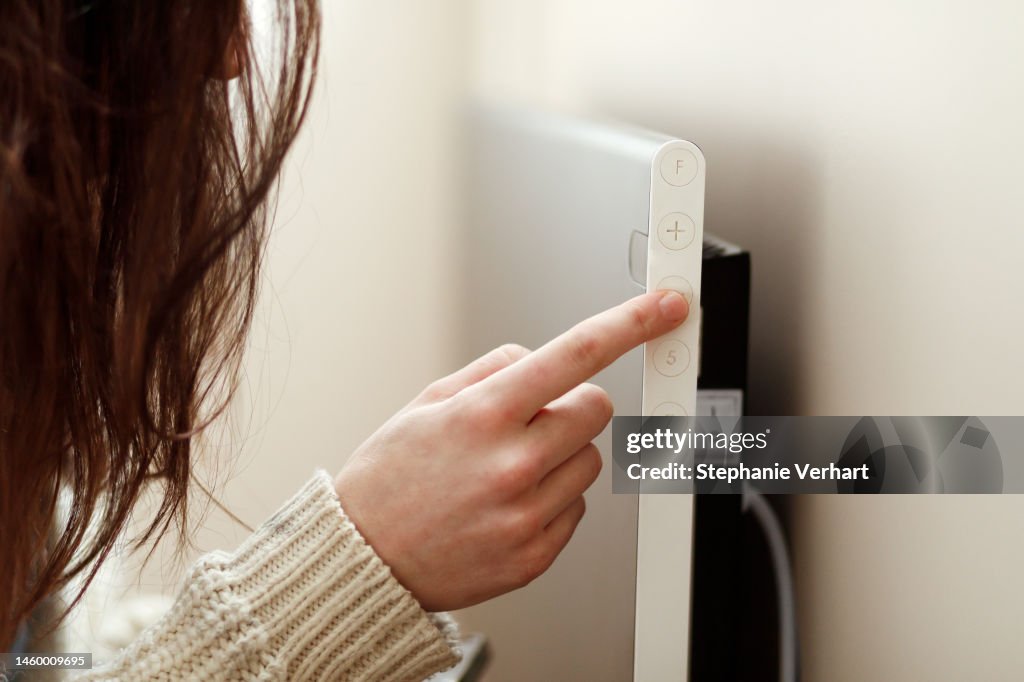 A hand setting the electric heater lower