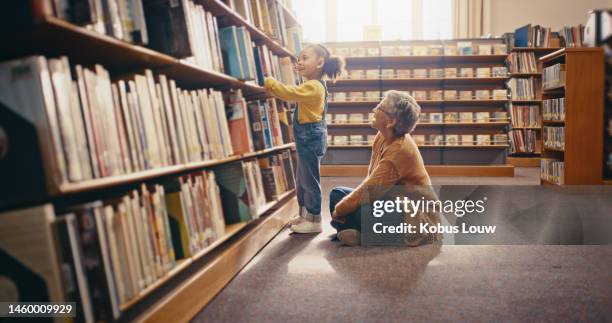 knowledge, grandmother and girl in library, education and bonding together, story time and learning. family, granny and female grandchild with books, search for stories and hobby to relax or be happy - learning generation parent child stock pictures, royalty-free photos & images