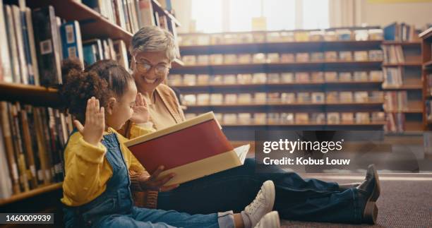 education, book and grandmother with grandchild on library floor, reading and happy, smile and playful. learning, books and girl with grandma, excited and cheerful for storytelling, fantasy and bond - bond girl fictional character stock pictures, royalty-free photos & images