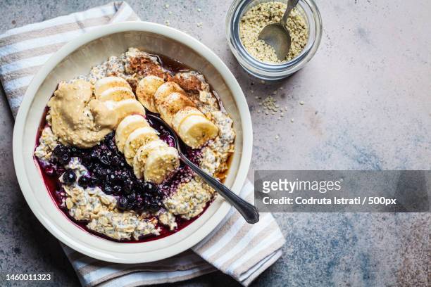 winter breakfast concept overnight oatmeal with banana,berry,chia seeds,sesame tahini,cinnamon,romania - hafer stock-fotos und bilder