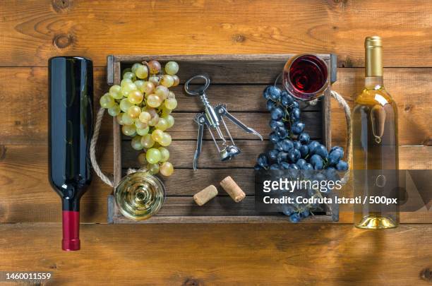 two bottles of wine and grapes in box on wooden background,romania - corkscrew foto e immagini stock