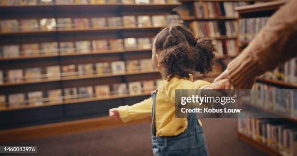 library, education and a girl holding hands while leading a woman through a bookstore for reading or learning. kids, walking and books with a female child looking for a book to read for development - leiden stockfoto's en -beelden