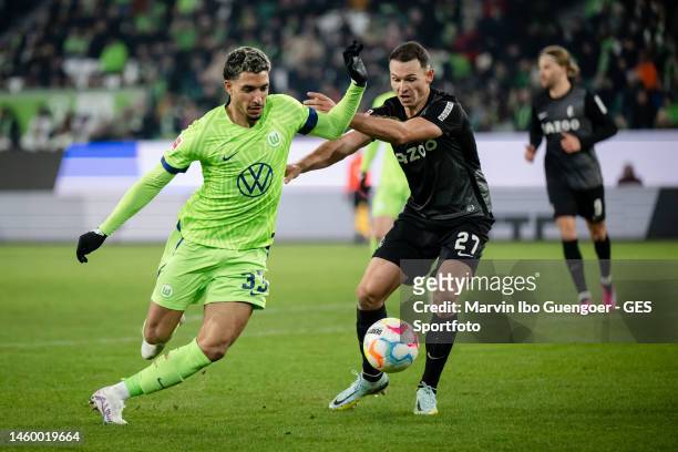 Omar Marmoush of Wolfsburg is tackled by Nicolas Hoefler of Freiburg during the Bundesliga match between VfL Wolfsburg and Sport-Club Freiburg at...