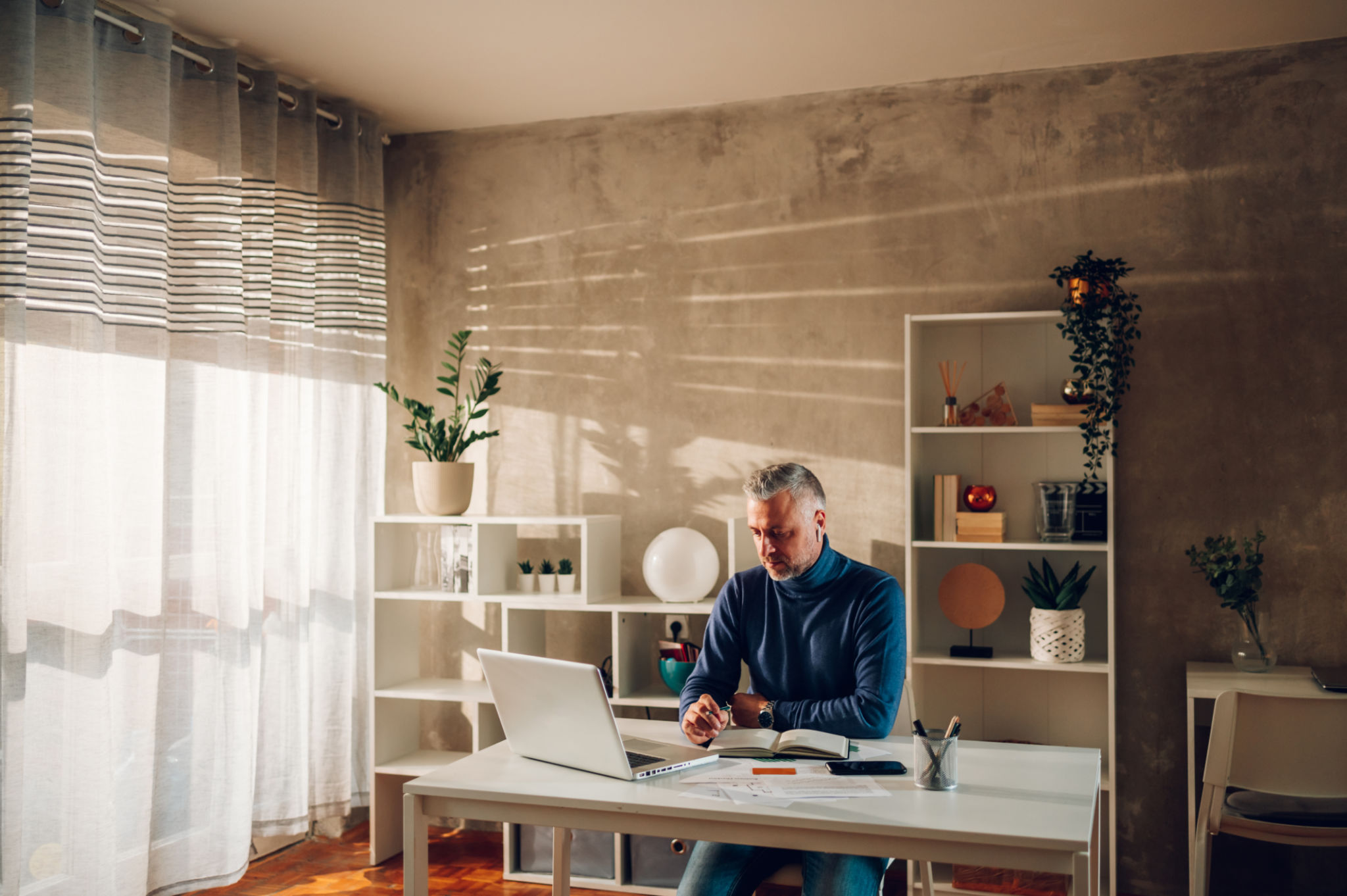 Middle aged man online shopping with laptop and a credit card at home Middle aged man online shopping with laptop and a credit card at home