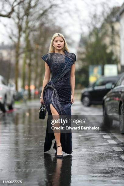 Caroline Hu wears silver earrings from Givenchy, a navy blue embroidered sequined / embossed wavy pattern / asymmetric shoulder / shoulder-off / wavy...