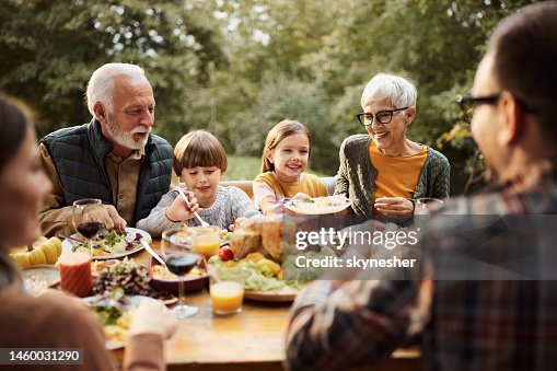 Happy multi-generation family having lunch in nature.