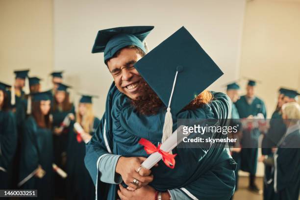 glückliches universitätspaar, das sich gegenseitig zum abschluss gratuliert. - graduation stock-fotos und bilder
