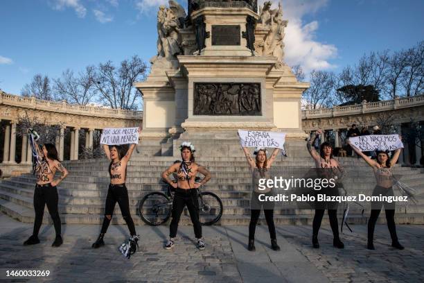 Activists with body paint hold banners reading 'for being a woman, not one less' , and 'Spain, country of femicides' and 'We are not born to be...