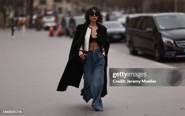 Xiayan seen wearing a long black coat, a white blazer, a black croptop and wide oversized jeans before the Georges Hobeika show on January 23, 2023...