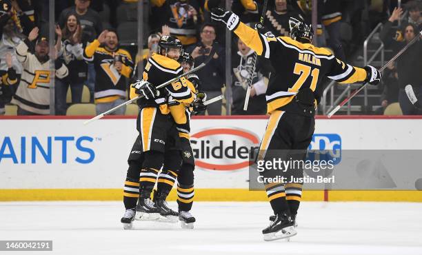 Kris Letang of the Pittsburgh Penguins celebrates with Sidney Crosby and Evgeni Malkin after scoring the game winning goal in overtime to give the...