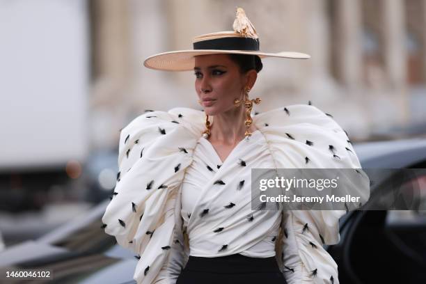 Sabina Jakubowicz seen wearing a white Schiaparelli top, hat and earrings with leggings by Loewe before the Schiaparelli show during Paris Fashion...